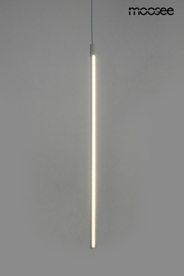 Biała lampa wisząca Ombre 80, jednoczęściowa, z wbudowanym źródłem światła LED o mocy 9W. Prosty, smukły kształt, zawieszona pionowo na cienkim przewodzie. Tło szare, co podkreśla minimalistyczny design.