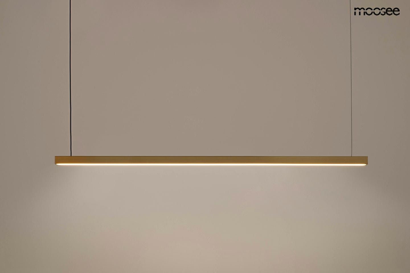 Lampa wisząca Linus 100 w kolorze złotym, wykonana z metalowego materiału, o prostokątnym kształcie. Zawieszona na cienkich, czarnych linkach, z wbudowanym źródłem światła LED o mocy 17W. Ujęcie frontalne na jednolitym tle.