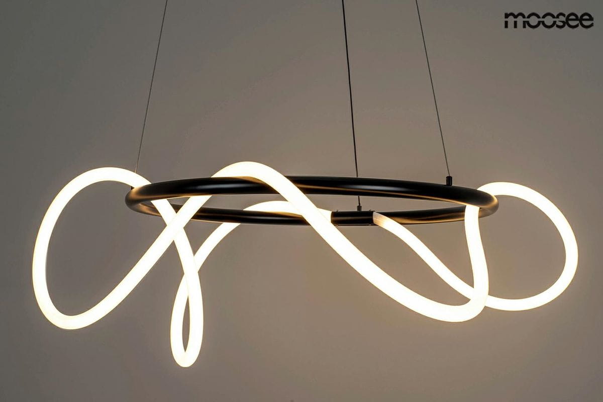 Lampa wisząca Serpiente w kolorze czarnym z jednym źródłem LED 35W. Posiada unikalny, organiczny kształt z białymi, podświetlającymi elementami w formie fal, zawieszona na cienkich linkach. Tło jasne, podkreślające nowoczesny design.