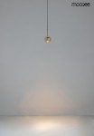 Lampa wisząca Ojo w kolorze złotym, z jedną żarówką LED o mocy 7W. Ujęcie z góry, lampa zawieszona na cienkim przewodzie w minimalistycznym otoczeniu. Widoczne subtelne odbicia światła na powierzchni pod lampą.
