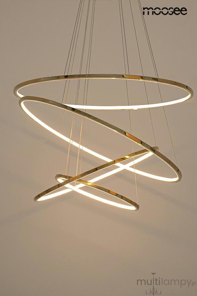 Lampa wisząca Ring Slim M w złotym kolorze z czterema pierścieniami LED, zawieszona na cienkich linkach. Światło emituje z wewnętrznych krawędzi pierścieni, tworząc nowoczesny efekt świetlny.