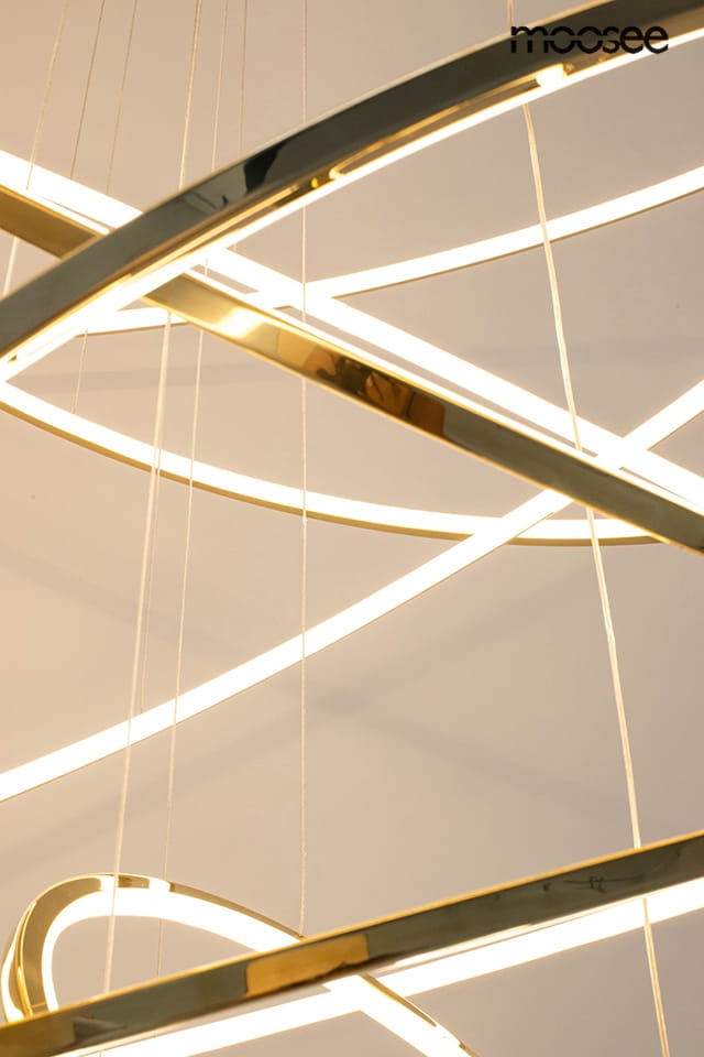 Lampa wisząca Ring Slim L w kolorze złotym z pięcioma diodami LED. Ujęcie z góry pokazuje nowoczesny, geometryczny kształt oraz podświetlane, okrągłe elementy. Produkt zawiera linki do zawieszenia, na białym tle.