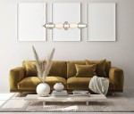 Lampa wisząca Gastel 1xLED/22W w kolorze czarnym, zawieszona nad kanapą, z dekoracyjnymi elementami w kształcie owalnym oraz metalowymi wykończeniami. Otoczenie obejmuje stół z dekoracjami i naturalnymi akcentami, na jasnym tle.
