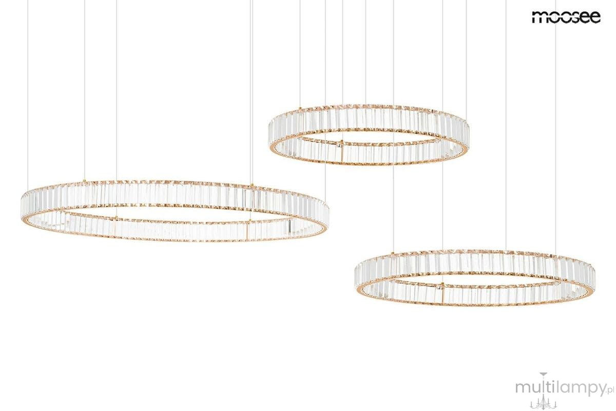 Lampa wisząca Liberty 3B z trzema okrągłymi elementami, wykonana z przezroczystego szkła i złotych detali. Zawieszona na cienkich linkach, w nowoczesnym stylu, idealna do eleganckiego wnętrza.
