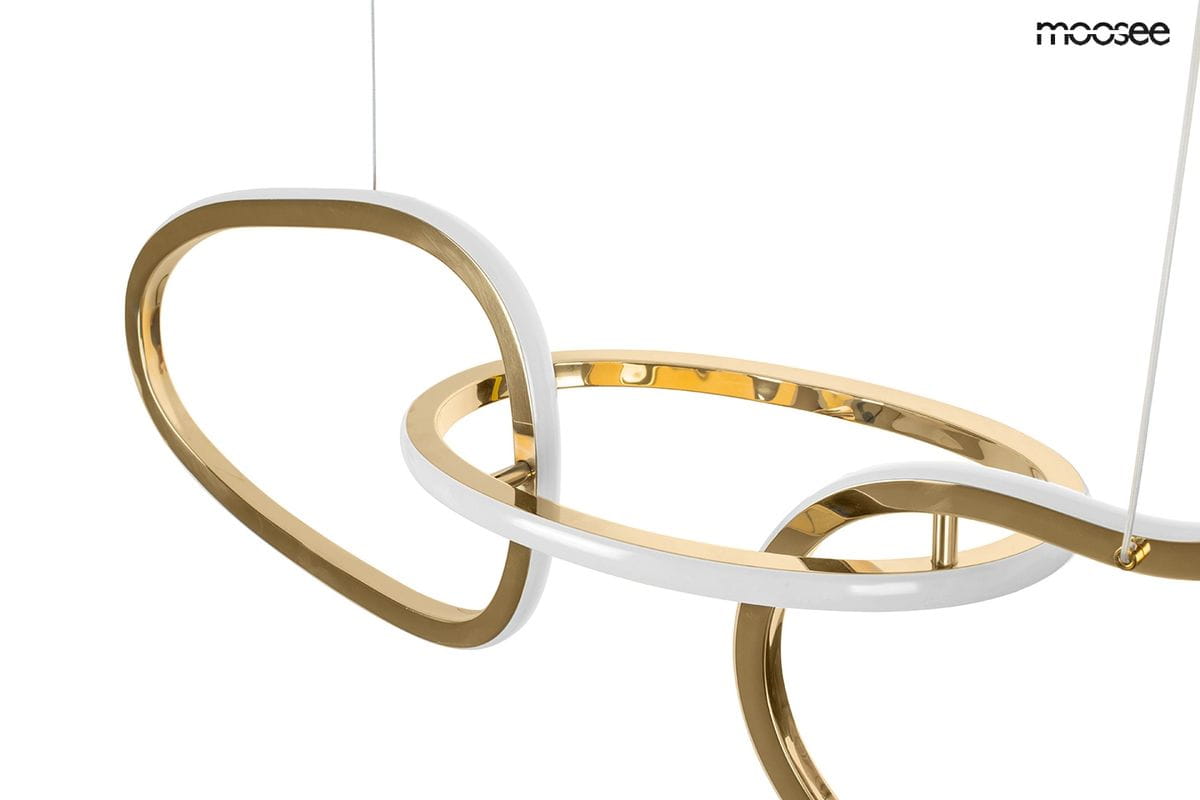 Lampa wisząca Jazz z trzema źródłami światła LED, wykonana z połączenia złotego metalu i białego tworzywa. Wykazuje nowoczesny, organiczny kształt, z wyraźnymi, płynnie zakrzywionymi liniami. Zawieszona na cienkich linkach, idealna do nowoczesnych wnętrz.