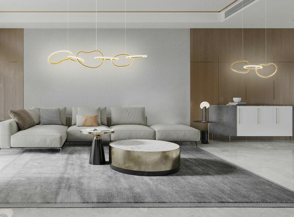 Lampa wisząca Jazz 3xLED/36W w kolorze złotym, o organicznej formie, zawieszona w nowoczesnym wnętrzu. Widoczna w aranżacji nad sofą, z jasnym tłem i minimalistycznymi meblami, tworzy elegancką atmosferę.