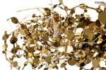 Lampa wisząca Monete 60 w kolorze złotym, z 12 źródłami światła G4, o organicznym kształcie z metalicznymi, okrągłymi detalami. Ujęcie z bliska ukazuje skomplikowaną strukturę i różnorodność elementów, tworzących efektowną kompozycję.