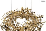 Lampa wisząca Monete 60 w kolorze złotym, z dekoracyjnymi elementami w formie okrągłych, metalicznych detali. Posiada osiemnaście miejsc na żarówki G4, zawieszona na cienkich linkach. Idealna do nowoczesnych wnętrz.