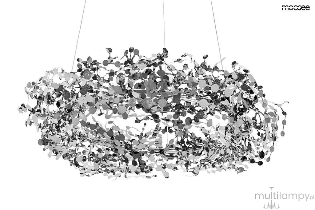 Lampa wisząca Monete 60 w kolorze chromu, o okrągłym, ażurowym kształcie, z dekoracyjnymi elementami w postaci metalicznych okręgów. Zawieszona na cienkich linkach, idealna do nowoczesnych wnętrz. Wymaga 12 żarówek G4.