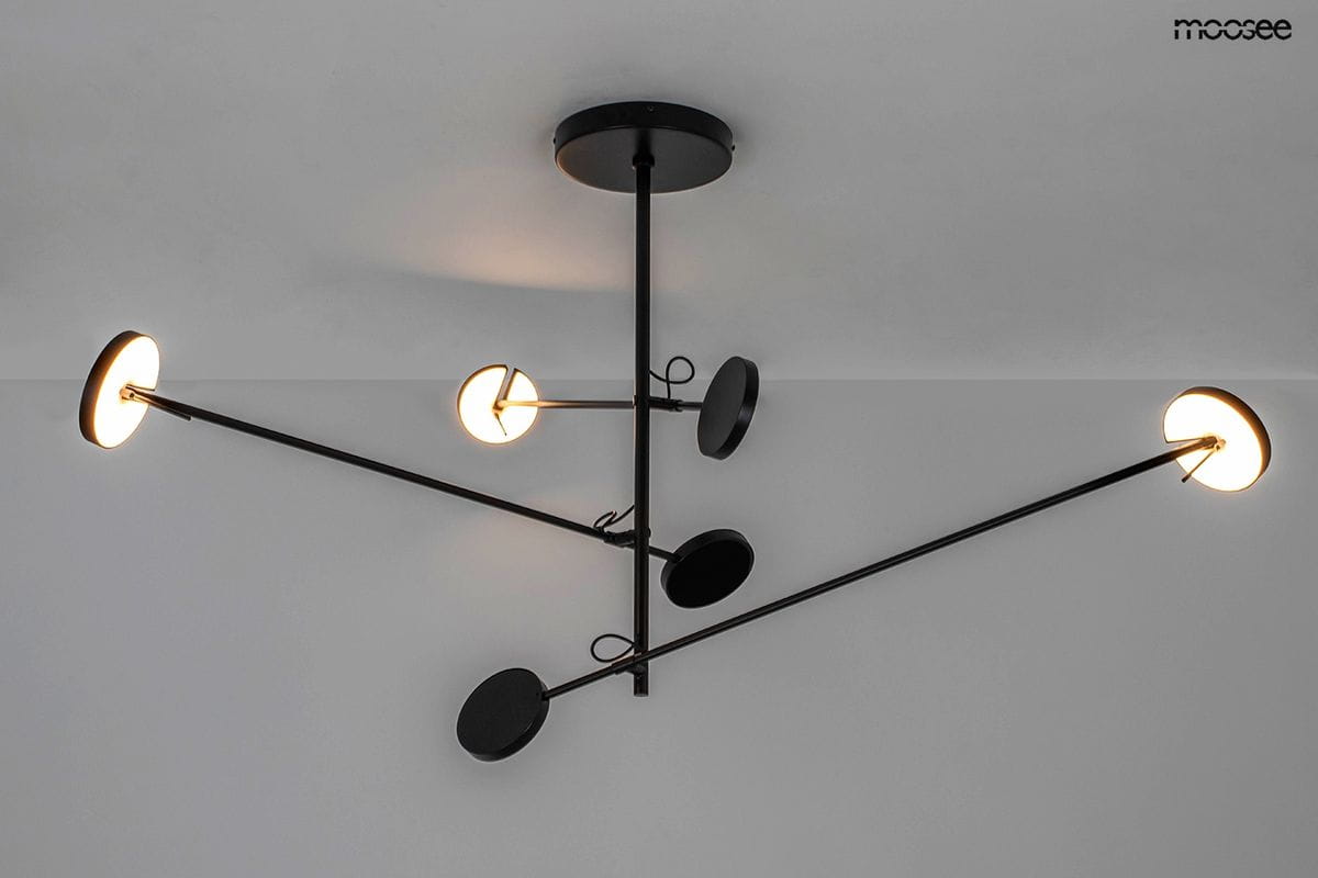 Lampa wisząca Bobbie w kolorze czarnym, z sześcioma źródłami światła LED (28W). Posiada minimalistyczny design z okrągłymi kloszami zamontowanymi na długich, prostych ramionach, umieszczona w centralnej części sufitu.