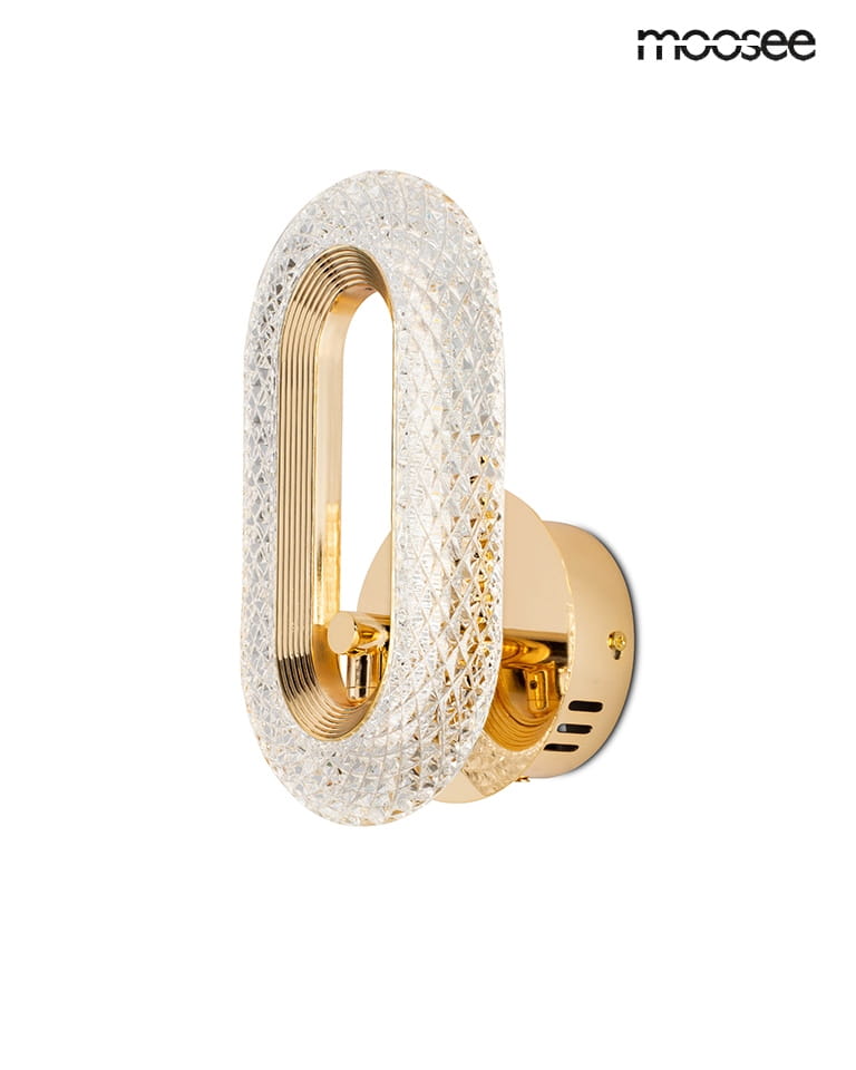 Kinkiet Jewel z pojedynczym źródłem LED 7W w kolorze złotym. Owalna lampa z przezroczystym, diamentowym wykończeniem, montowana na ścianie. Elegancki design z widocznym miejscem na żarówkę oraz dekoracyjnymi detalami.