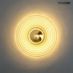 Kinkiet Onda LED 1xLED/9W w kolorze złotym, okrągły klosz z falistym wzorem, montowany na ścianie. Emituje ciepłe światło, centralny element w kolorze złotym. Tło jasne, minimalistyczne.