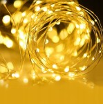Girlanda świetlna ogrodowa solarna o długości 50 m z 500 diodami LED, umieszczona na cienkim, złotym drucie. Ujęcie w zbliżeniu, ukazujące migoczące światła na tle ciemniejszym. Idealna do dekoracji ogrodów i przestrzeni na zewnątrz.