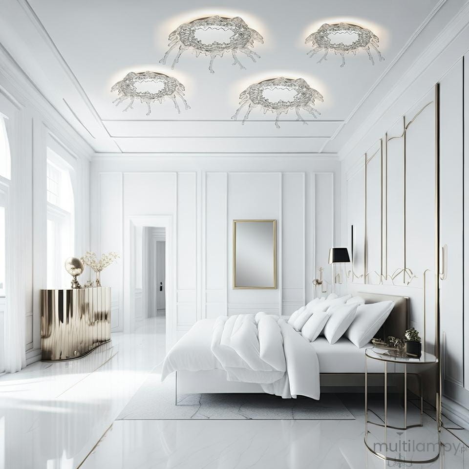 Kinkiet Splash M w kolorze chromu z jedną diodą LED o mocy 17W, zamontowany na suficie. Nowoczesny design z elementami dekoracyjnymi, idealny do eleganckiego wnętrza. Widoczny w minimalistycznej sypialni na tle białych ścian.
