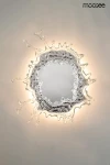 Kinkiet Splash M z chromowaną ramą w kształcie kropli wody, z centralnym lustrzanym panelem. Oświetlenie LED o mocy 17W emituje ciepłe światło, tworząc efekt przestrzeni. Zawieszony na ścianie, prezentuje nowoczesny design.