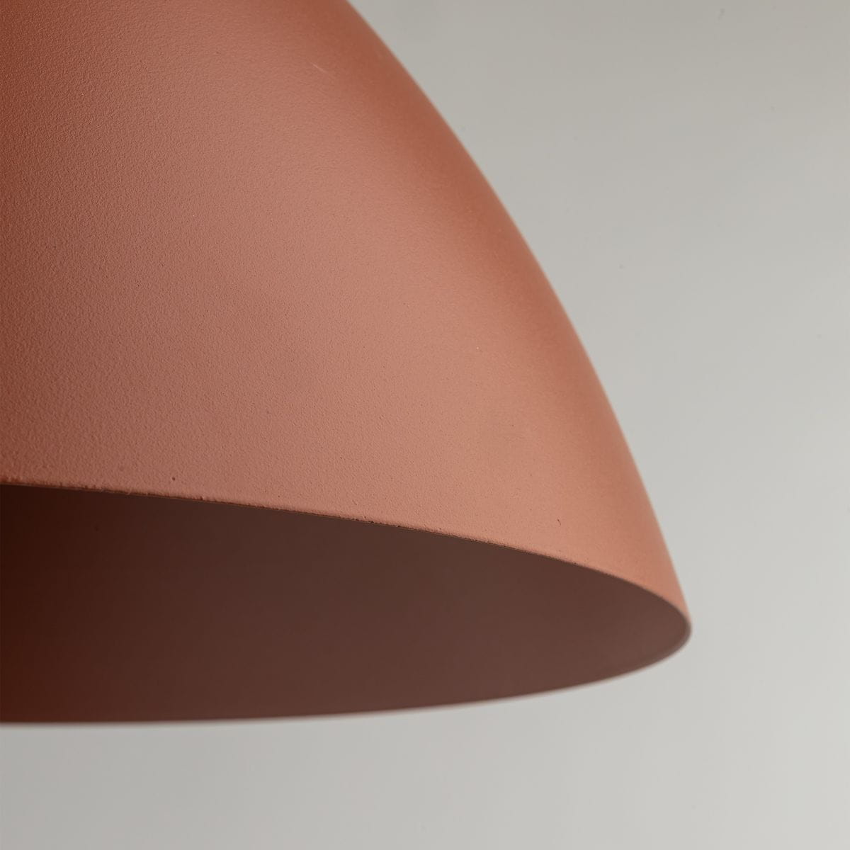 Lampa wisząca Faro D34 w ceglastej barwie z matowym wykończeniem, z okrągłym kloszem w kształcie stożka. Ujęcie z bliska na górną część klosza, ukazujące jego teksturę. Przeznaczona na żarówkę E27.
