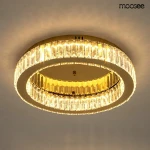Lampa sufitowa Borra z złotą obręczą, wyposażona w diodę LED 25W. Ma okrągły kształt, z transparentnym kloszem, który odbija światło. Ujęcie z dołu, ukazujące detale konstrukcji oraz efekt świetlny. Idealna do nowoczesnych wnętrz.