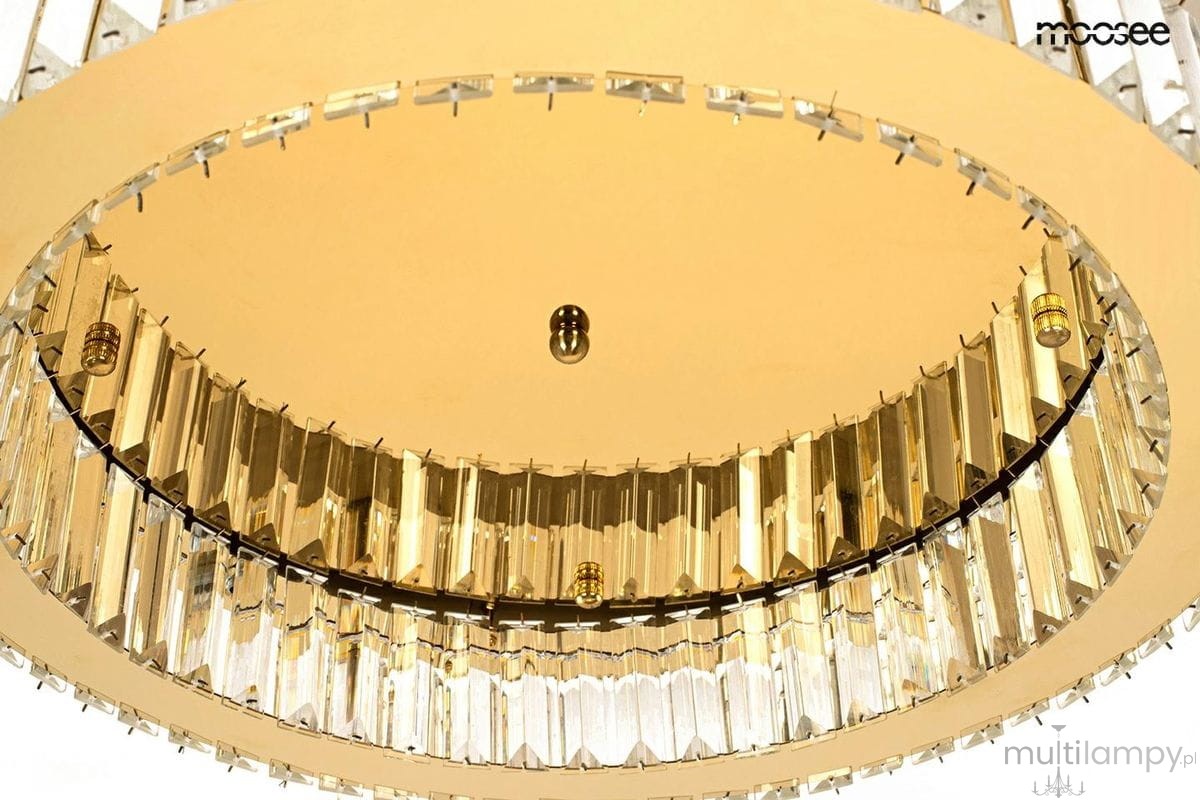 Lampa sufitowa Borra z jedną diodą LED o mocy 25W, złota, z okrągłym kloszem i dekoracyjnymi, przezroczystymi elementami. Ujęcie z dołu, ukazujące szczegóły wykończenia oraz centralne mocowanie.