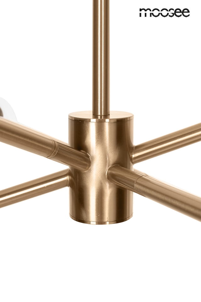 Lampa wisząca Aura w kolorze złotym, z miejscem na sześć żarówek E14. Widoczny detal metalowej podstawy z rozgałęzieniami w kształcie rur. Prosty design, idealna do nowoczesnych wnętrz.