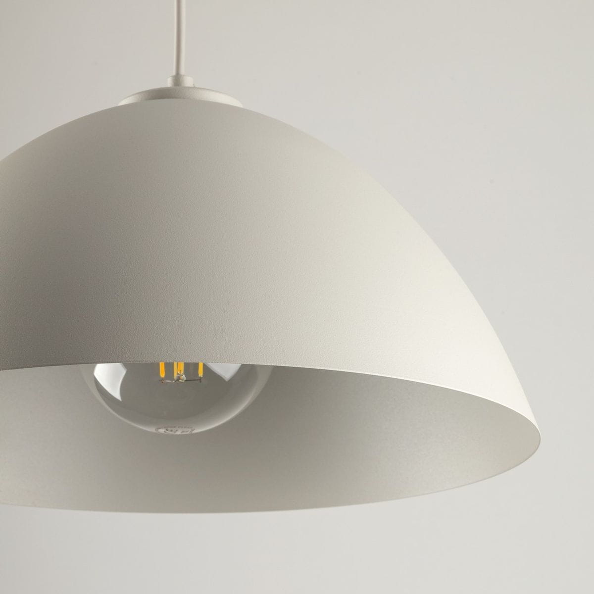 Beżowa lampa wisząca Faro D34 z kloszem w kształcie półkuli, wykonana z matowego materiału. Widoczny gwint E27 oraz źródło światła w środku. Kąt ujęcia zbliżony na detal klosza. Tło jasne, neutralne.