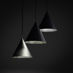 Lampa wisząca Cono z trzema kloszami w kształcie stożków, w kolorze czarnym i szarym, zawieszona na cienkich linkach. Klosze mają matową fakturę, a ich wnętrza są jasne, co podkreśla ich nowoczesny design.