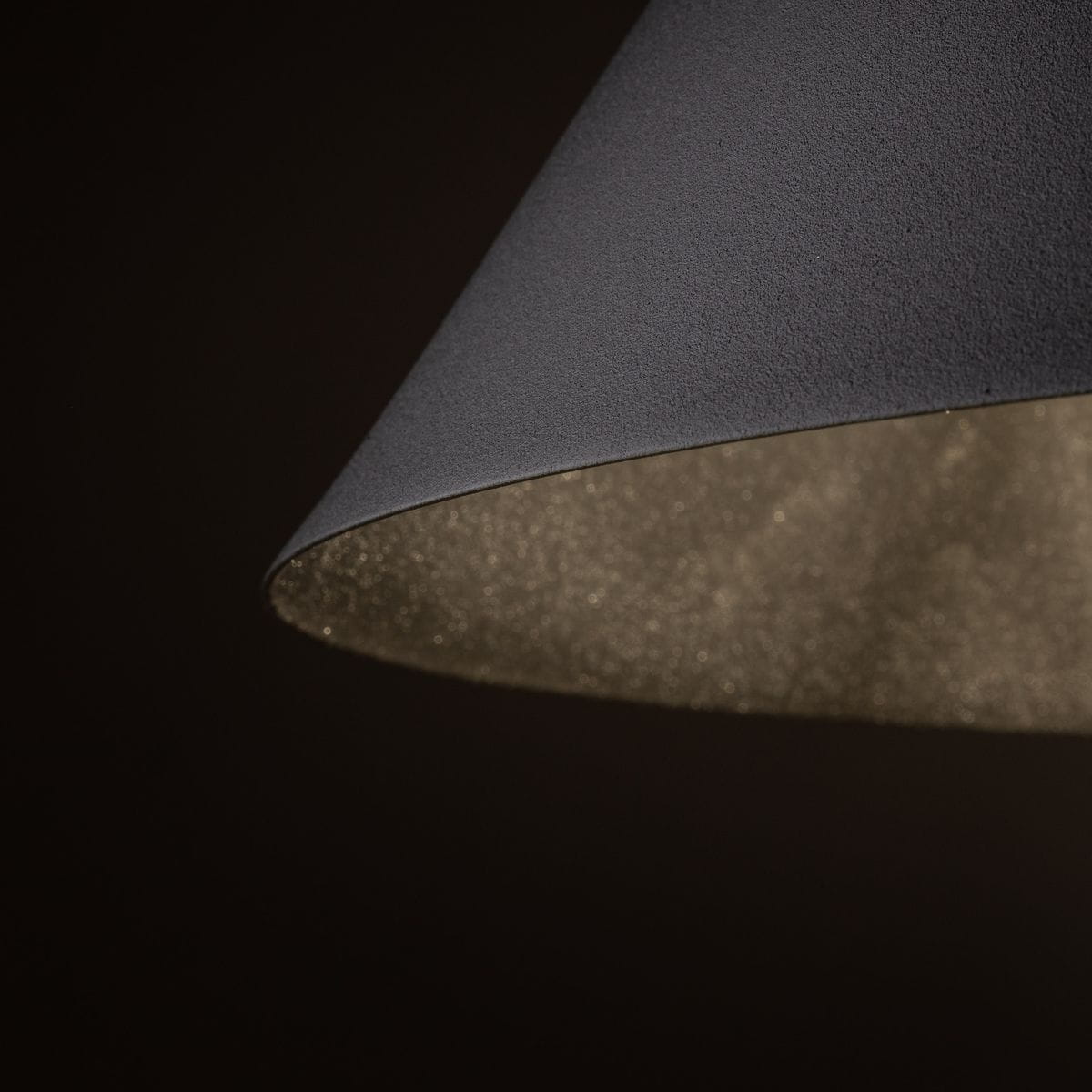 Czarna lampa wisząca Cono D50 z kloszem w kształcie stożka. Wnętrze klosza pokryte złotym, błyszczącym wykończeniem. Ujęcie w zbliżeniu na krawędź klosza, ukazujące teksturę zewnętrzną. Produkt przeznaczony do jednej żarówki E27.