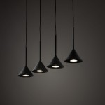 Czarna lampa wisząca Cono z czterema kloszami w kształcie stożka, zawieszona na cienkich kablach. Klosze mają matową powierzchnię i są ustawione w linię, emitując światło z żarówek GU10. Tło jest ciemne, co podkreśla elegancki wygląd lampy.