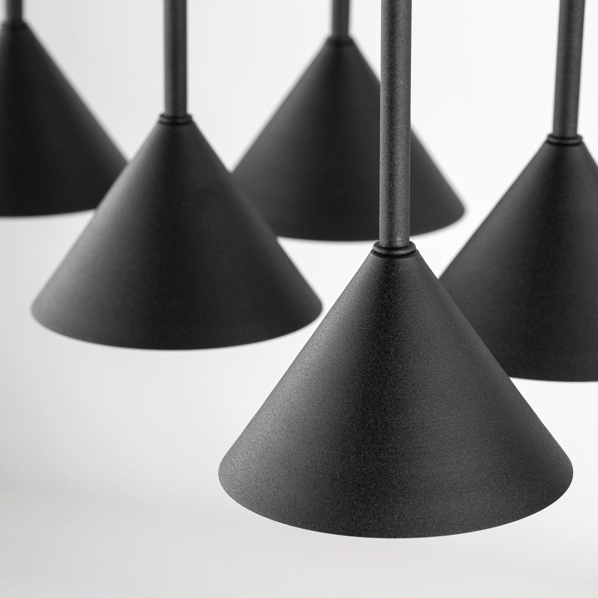 Lampa wisząca Cono z sześcioma kloszami w kształcie stożków, wykonana w matowym czarnym kolorze. Klosze zawieszone na cienkich linkach, widoczne detale konstrukcyjne. Produkt pokazany z bliska, na jednolitym tle.