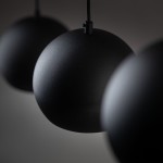 Czarna lampa wisząca Zoe z trzema okrągłymi kloszami E27, zawieszona na cienkich przewodach. Klosze mają matową powierzchnię, tworząc minimalistyczny design, idealny do nowoczesnych wnętrz. Ujęcie zbliżeniowe na detale kloszy.