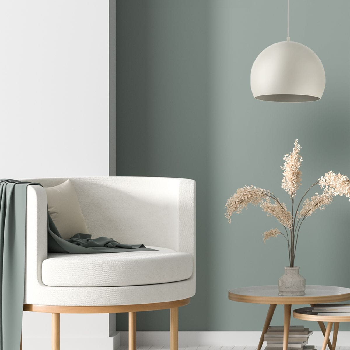Beżowa lampa wisząca Zoe D17 z jednym gniazdem E27, o zaokrąglonym kształcie, zawieszona nad eleganckim fotelem w białym kolorze, w otoczeniu stonowanej zielonej ściany i dekoracyjnych kwiatów w wazonie.