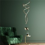 Lampa wisząca Coco w kolorze złotym, z pilotem, z dwoma źródłami światła LED o mocy 68W. Ma spiralny kształt i jest zawieszona nad zielonym, welurowym fotelem w nowoczesnym wnętrzu. W tle ciemnozielona ściana.
