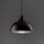 Lampa wisząca Cap 1xE27 w kolorze brązowym, z metalowym kloszem o zaokrąglonym kształcie i drewnianym elementem u góry. Zawieszona na cienkim przewodzie, idealna do nowoczesnych wnętrz. Tło w odcieniu szarości.
