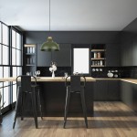 Lampa wisząca Cap w kolorze zielonym z oprawą E27, zawieszona nad drewnianym blatem w nowoczesnej kuchni. W tle czarne meble, szklane naczynia oraz roślinność. Kąt ujęcia frontalny, uchwycone detale i kontekst aranżacji.
