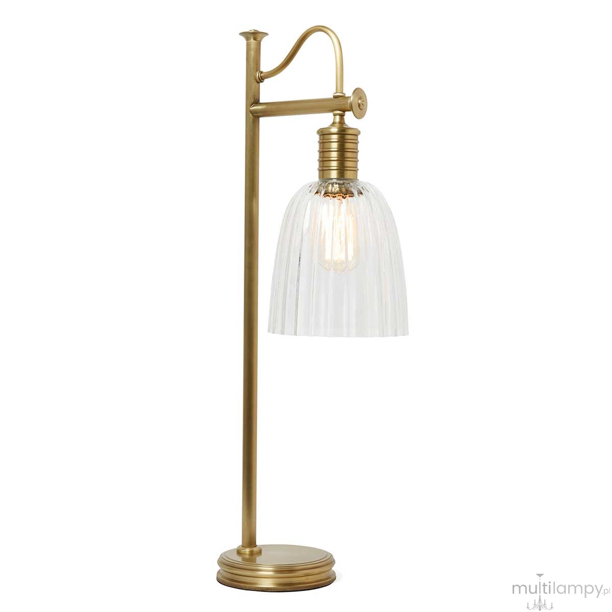 Lampa stołowa z postarzanym mosiądzu, z przezroczystym kloszem w kształcie dzwonu. Ustawiona pionowo, z widoczną żarówką E27. Klosz o żłobieniach, z prostą podstawą i eleganckim uchwytem. Tło białe, co podkreśla detal produktu.