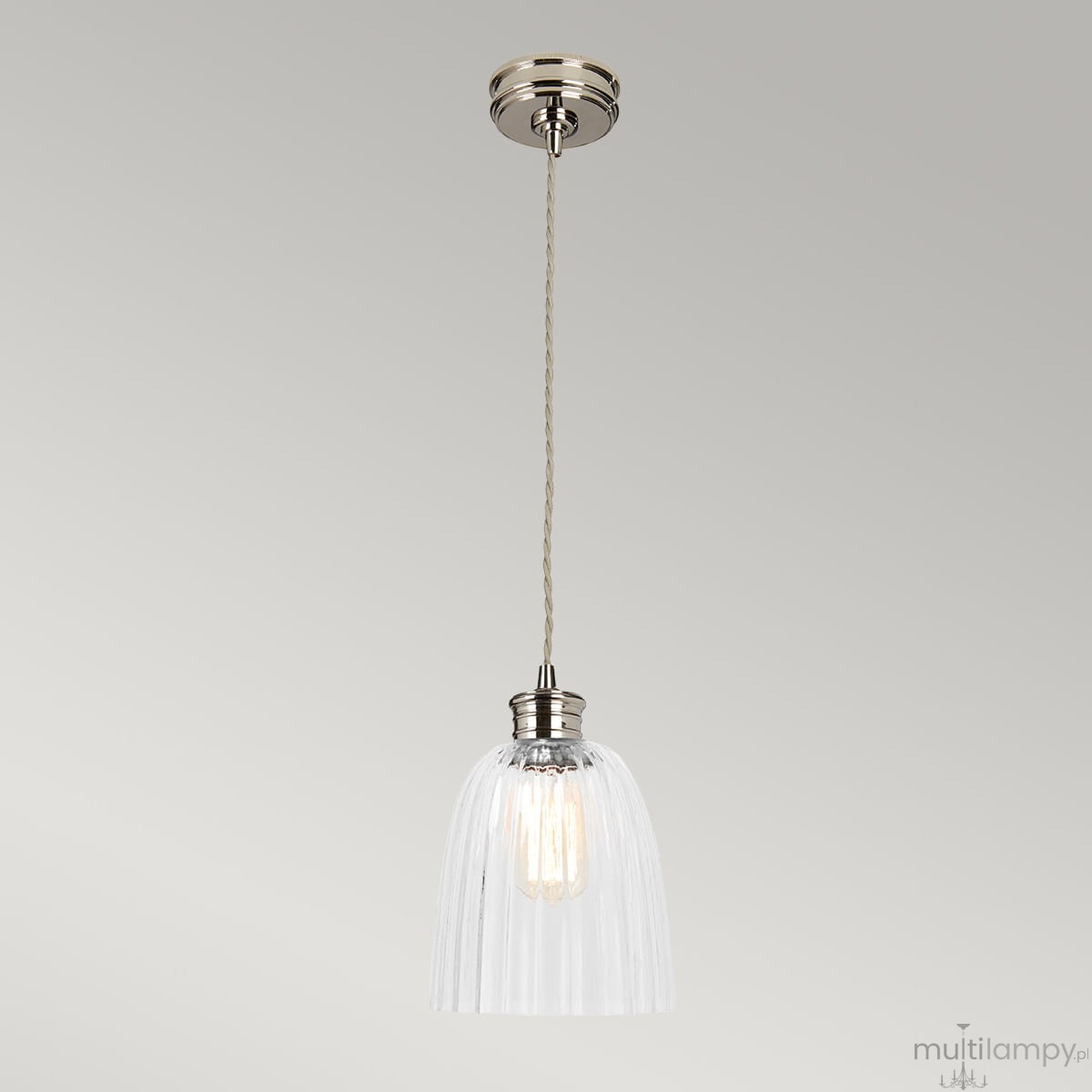 Lampa wisząca z kloszem z przezroczystego szkła, polerowany nikiel u góry, z zawieszeniem na sznurku. Klosz ma kształt stożkowaty z pionowymi żłobieniami. Widoczna żarówka E27 wewnątrz. Kąt ujęcia frontalny, na jednolitym tle.