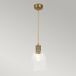 Lampa wisząca z postarzanym mosiężnym trzonkiem i szklanym kloszem w kształcie stożka. Klosz ma delikatne żłobienia, zawieszona na plecionym kablu. Produkt montowany sufitowo, w kolorze złotym z przezroczystym kloszem.