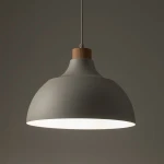 Beżowa lampa wisząca Cap z oprawą w kształcie półkuli, wykonana z matowego materiału, z drewnianym detalem u góry. Zawieszona na cienkim przewodzie, emituje światło z dolnej krawędzi, idealna do nowoczesnych wnętrz.