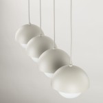 Lampa wisząca Bono w beżowym kolorze, z czterema półkulistymi kloszami, zawieszona na białych przewodach. Klosze mają matowe wykończenie, a dolna część jest lekko przezroczysta, co tworzy efekt subtelnego oświetlenia.
