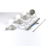 Beżowa lampa wisząca Bono z czterema okrągłymi kloszami z matowego szkła. Produkt leży na białym tle, z widocznymi przewodami i metalowym uchwytem montażowym. Klosze mają kształt półkulisty, a ich kolorystyka jest stonowana.