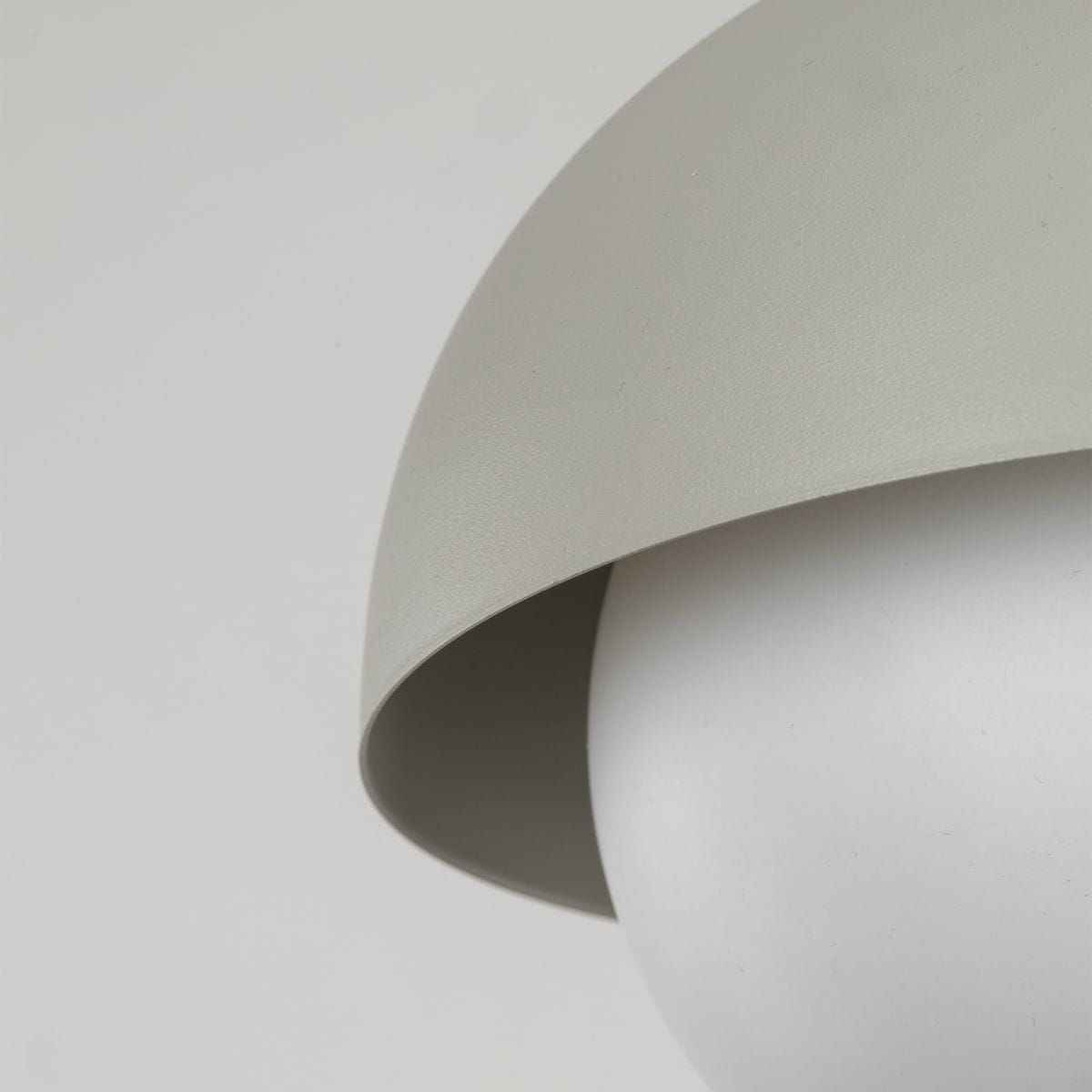 Lampa wisząca Bono D17 w kolorze beżowym z kloszem w kształcie półkuli, wykonanym z matowego materiału. Widoczny uchwyt w górnej części, montowana na suficie. Wnętrze klosza w kolorze białym, przeznaczona na żarówkę G9.