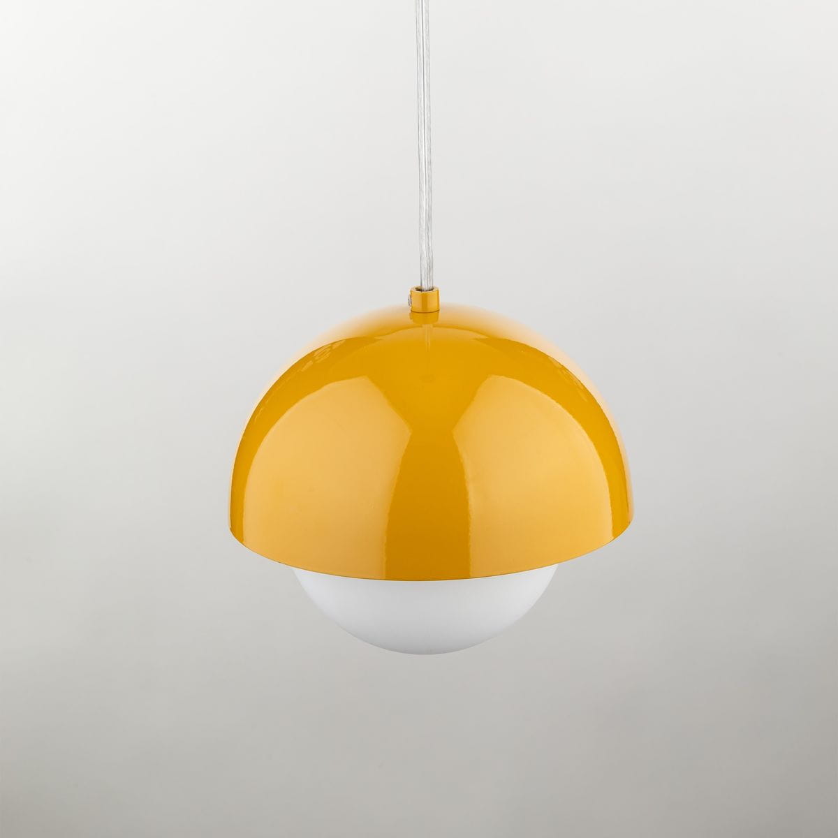 Lampa wisząca Bono D17 w kolorze ochra z metalowym kloszem w kształcie półkuli, z białym, matowym dnem. Zawieszona na cienkim, białym przewodzie. Idealna do nowoczesnych wnętrz.