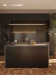 Lampa wisząca Organic D150 w kolorze złotym, zawieszona nad ciemnym blatem kuchennym. Posiada jedną żarówkę LED o mocy 26W. Prosty, nowoczesny design, idealna do aranżacji kuchni. W tle widoczne elementy kuchenne oraz roślinność.