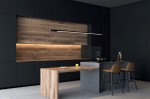 Lampa wisząca Organic 150 w kolorze czarnym, z jedną żarówką LED o mocy 26W. Zamontowana nad wyspą kuchenną, prostokątna, minimalistyczna konstrukcja. W tle widoczne ciemne meble i drewniane akcenty.