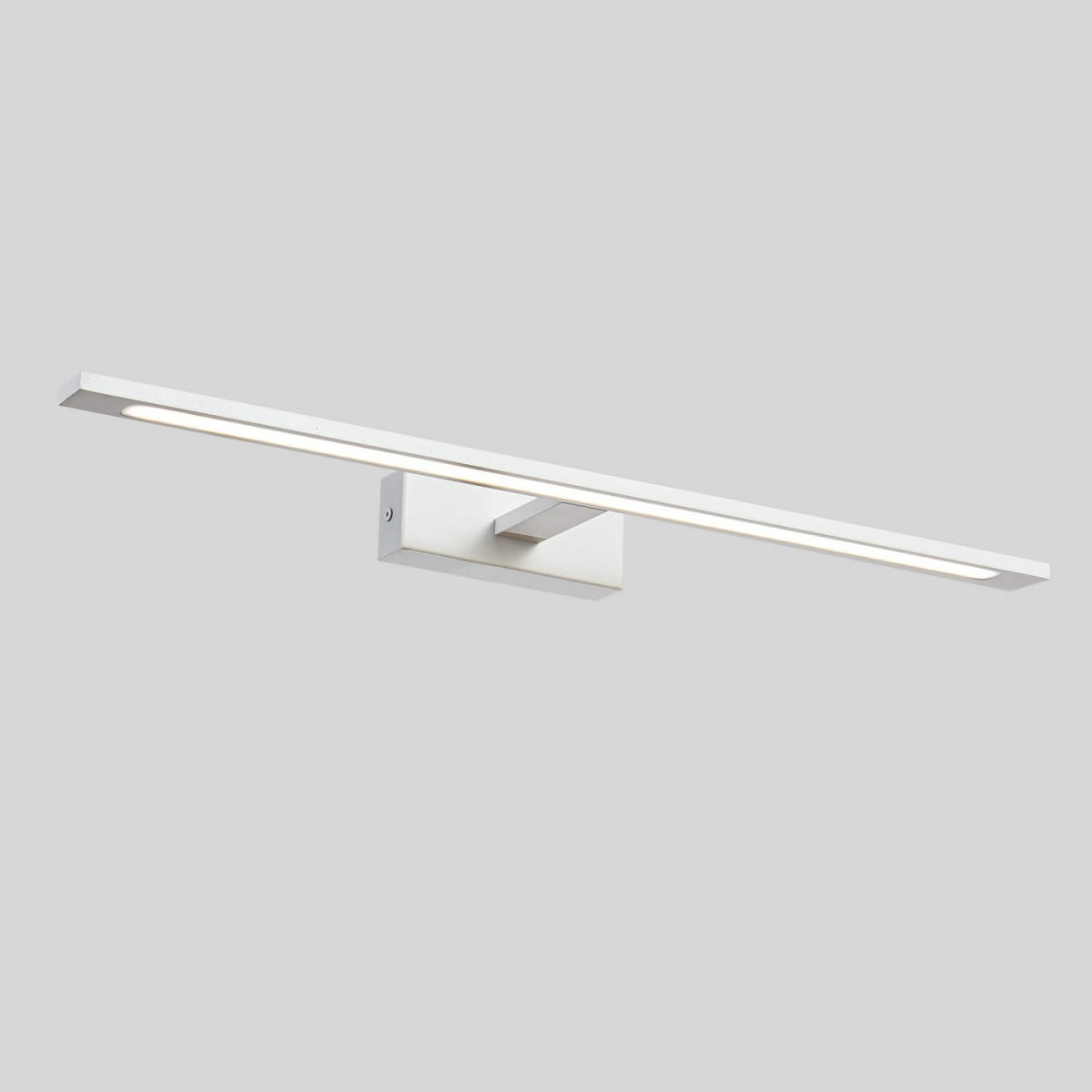 Kinkiet LED Isla IP44 w kolorze białym, o długości 62 cm i mocy 20W. Posiada prostokątną formę z cienką, podłużną oprawą, zamontowaną na kwadratowej podstawie. Oświetlenie rozproszone, idealne do łazienek lub innych wilgotnych pomieszczeń.