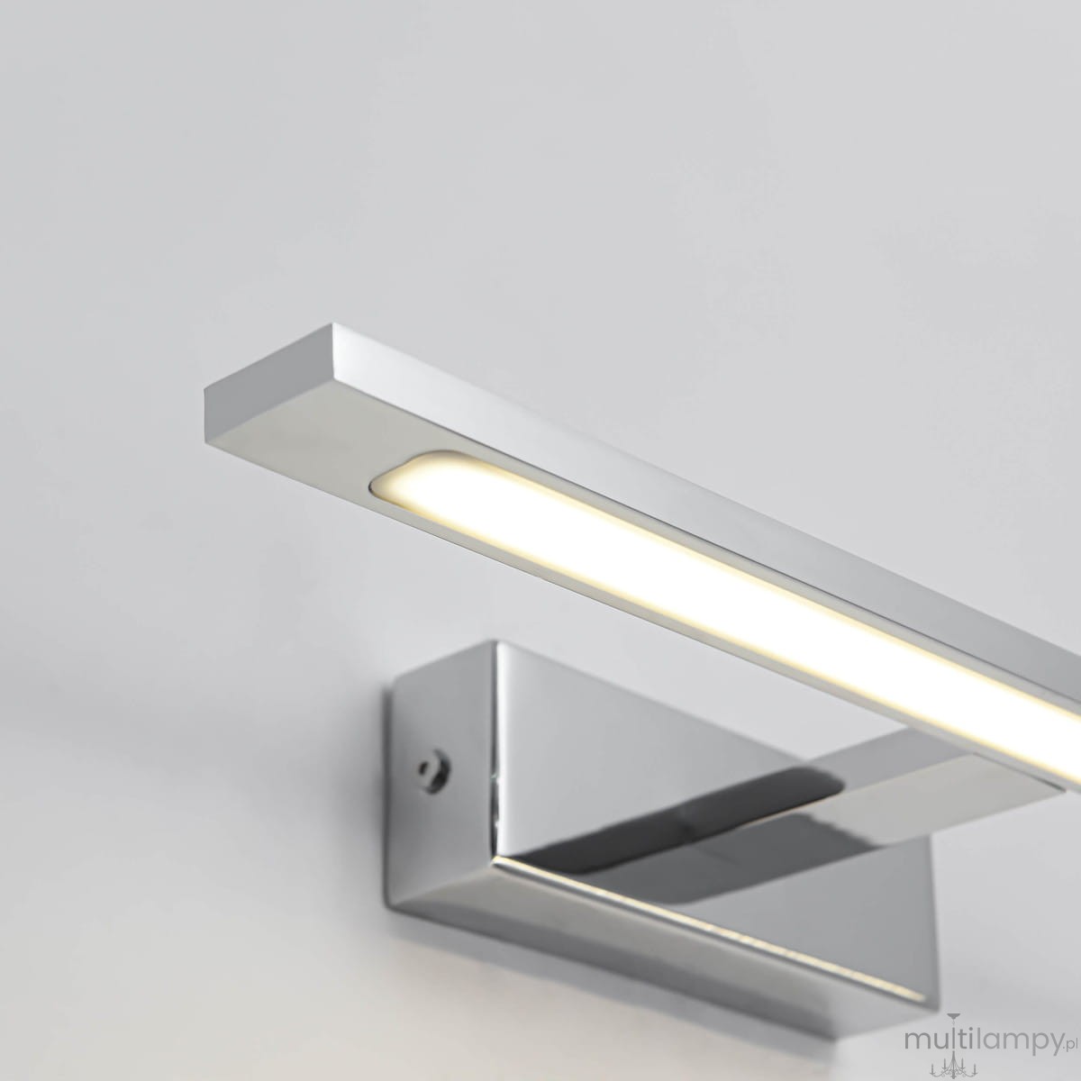 Kinkiet LED Isla IP44 w kolorze chromu, prostokątny, zamontowany na ścianie. Wyposażony w wąski pasek światła LED, emitujący ciepłe światło. Gładka, błyszcząca powierzchnia, nowoczesny design, idealny do oświetlenia wnętrz.