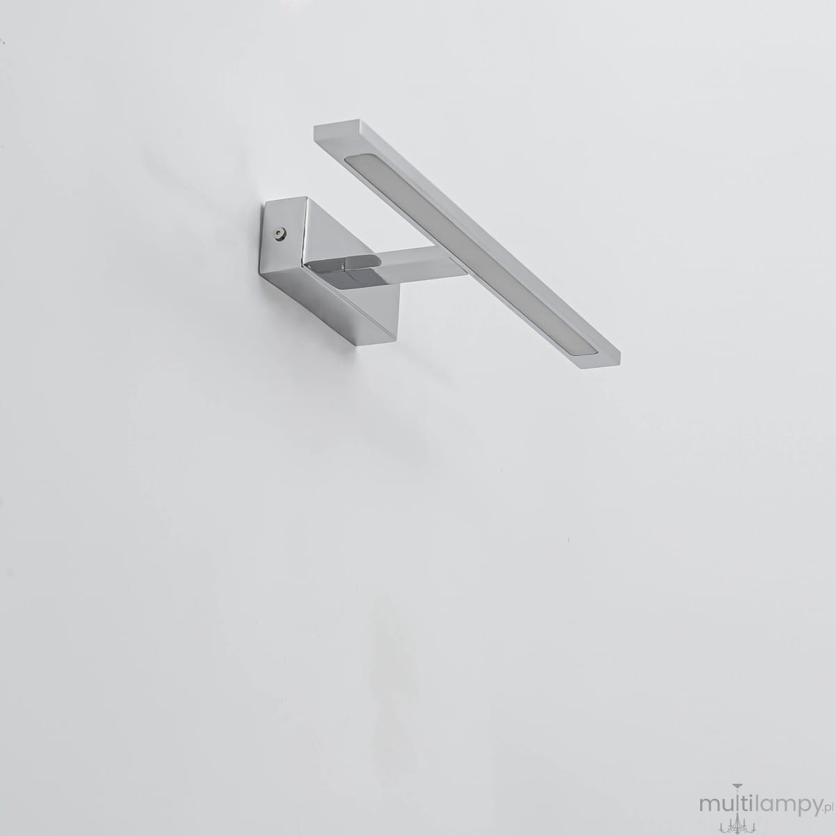 Kinkiet LED Isla IP44 w kolorze chromu, z prostokątną, płaską oprawą. Zainstalowany na ścianie w pozycji poziomej. Wykończenie błyszczące, minimalistyczny design, idealny do nowoczesnych wnętrz. Tło jasne, neutralne.