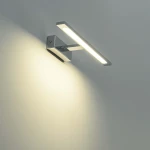 Kinkiet LED Isla IP44 w kolorze chromu, w kształcie prostokąta, montowany na ścianie. Emituje ciepłe światło, z widoczną obudową o minimalistycznym designie. Zainstalowany pod kątem, idealny do nowoczesnych wnętrz.