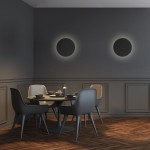Luna kinkiet 3xG9 w kolorze czarnym, zamontowany na ścianie w jadalni. Oświetlenie tworzy okrągły efekt świetlny na tle szarej ściany. W tle widoczny stół z krzesłami i naczyniami w minimalistycznym stylu.