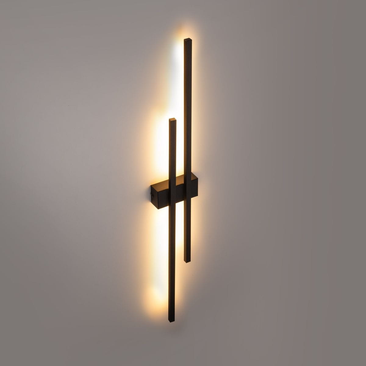 Kinkiet Flash 2xLED/24W w kolorze czarnym, zamontowany na ścianie. Składa się z dwóch prostokątnych, pionowych elementów emitujących ciepłe światło. Obudowa wykonana z matowego materiału, minimalistyczny design, tło jednolite.