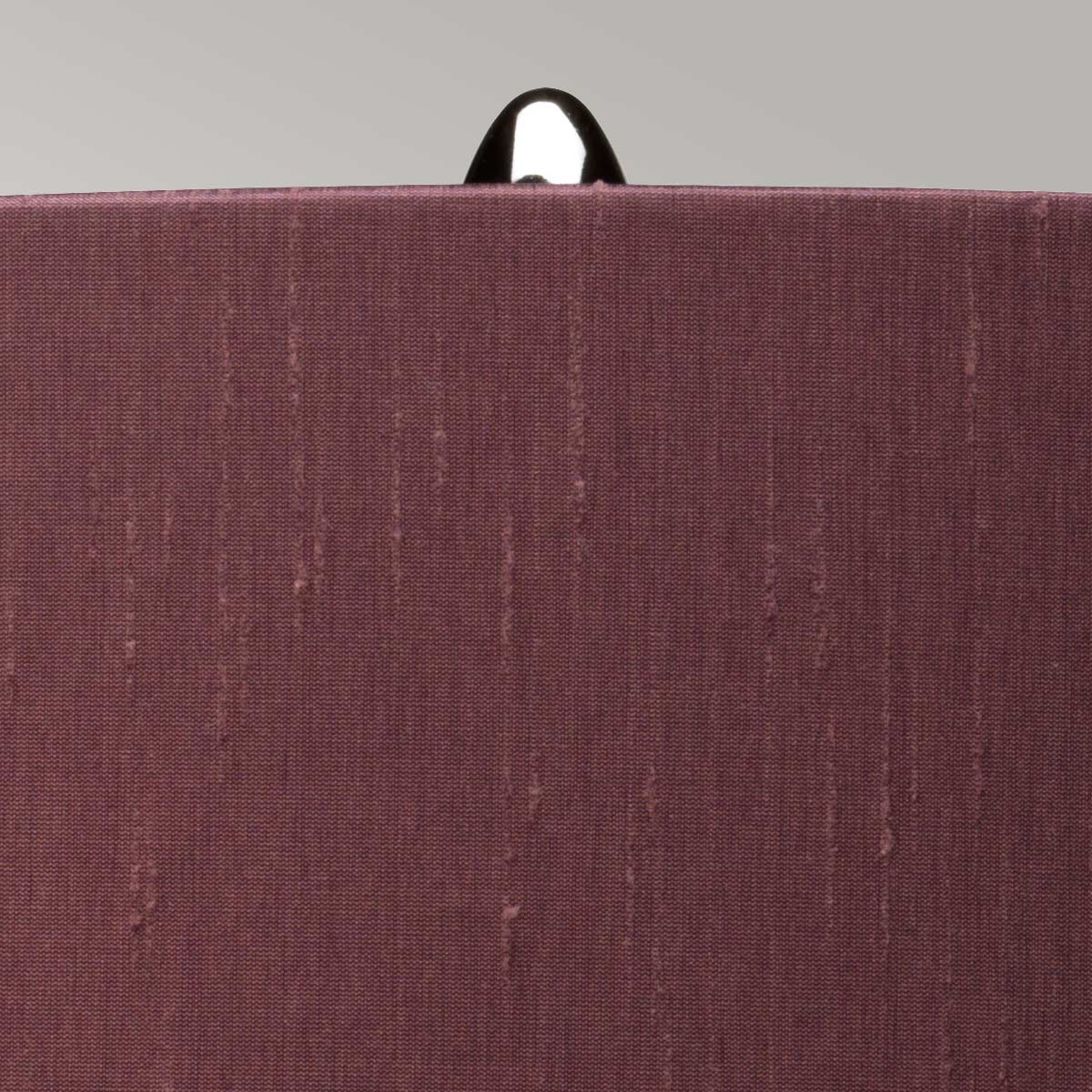 Lampka stołowa Kara w szarym kolorze z materiałowym kloszem. Widoczny detal górnej części klosza z metalowym uchwytem. Klosz o teksturowanej powierzchni, stojący na stabilnej podstawie. Prosta forma, idealna do nowoczesnych wnętrz.